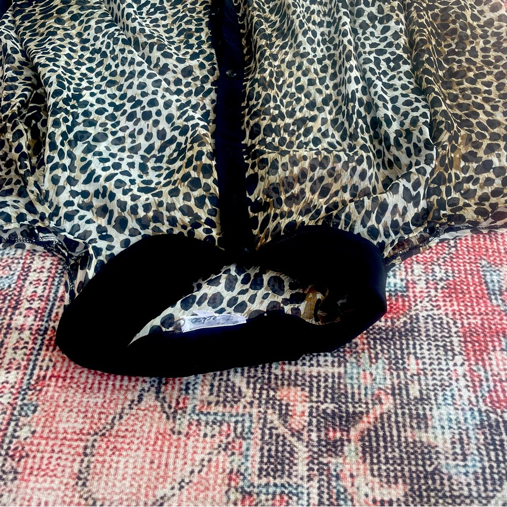 Sheer, long sleeve blouse with cut out shoulders. 100% polyester. Hand wash cold